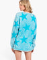 A woman shown from the back wearing a light blue long-sleeve sweatshirt with a darker blue star pattern, set against a plain white studio background.