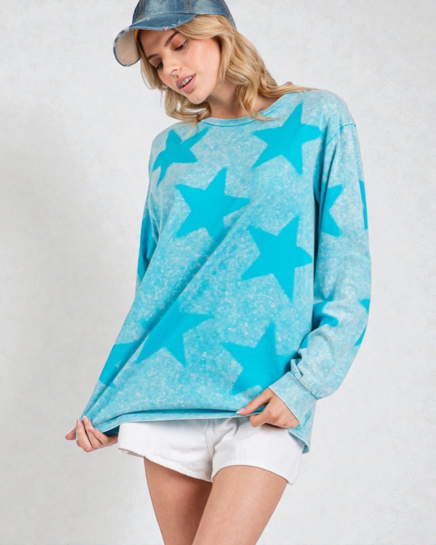 Woman wearing a blue star-patterned sweater on a plain background