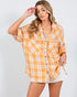 Woman wearing a yellow and white plaid shirt on a white background