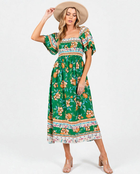 Woman wearing a green floral dress with a white background