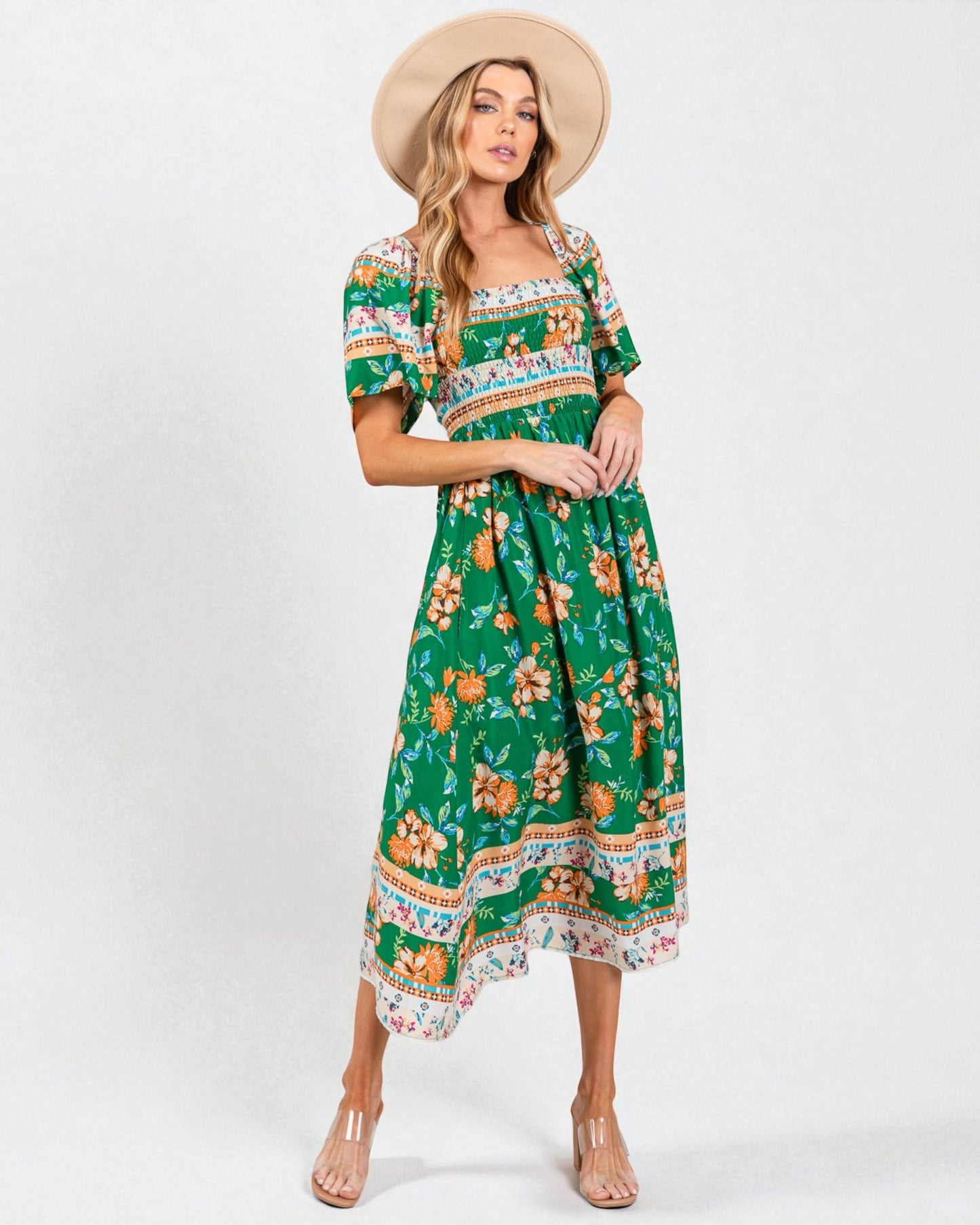 Woman wearing a green floral dress with a white background