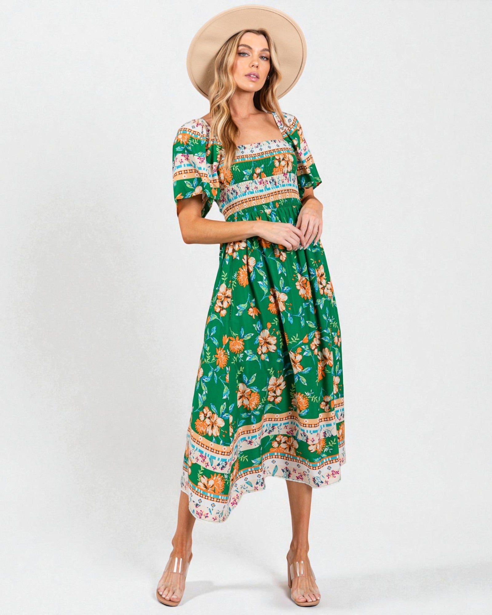 Woman wearing a green floral dress with a white background