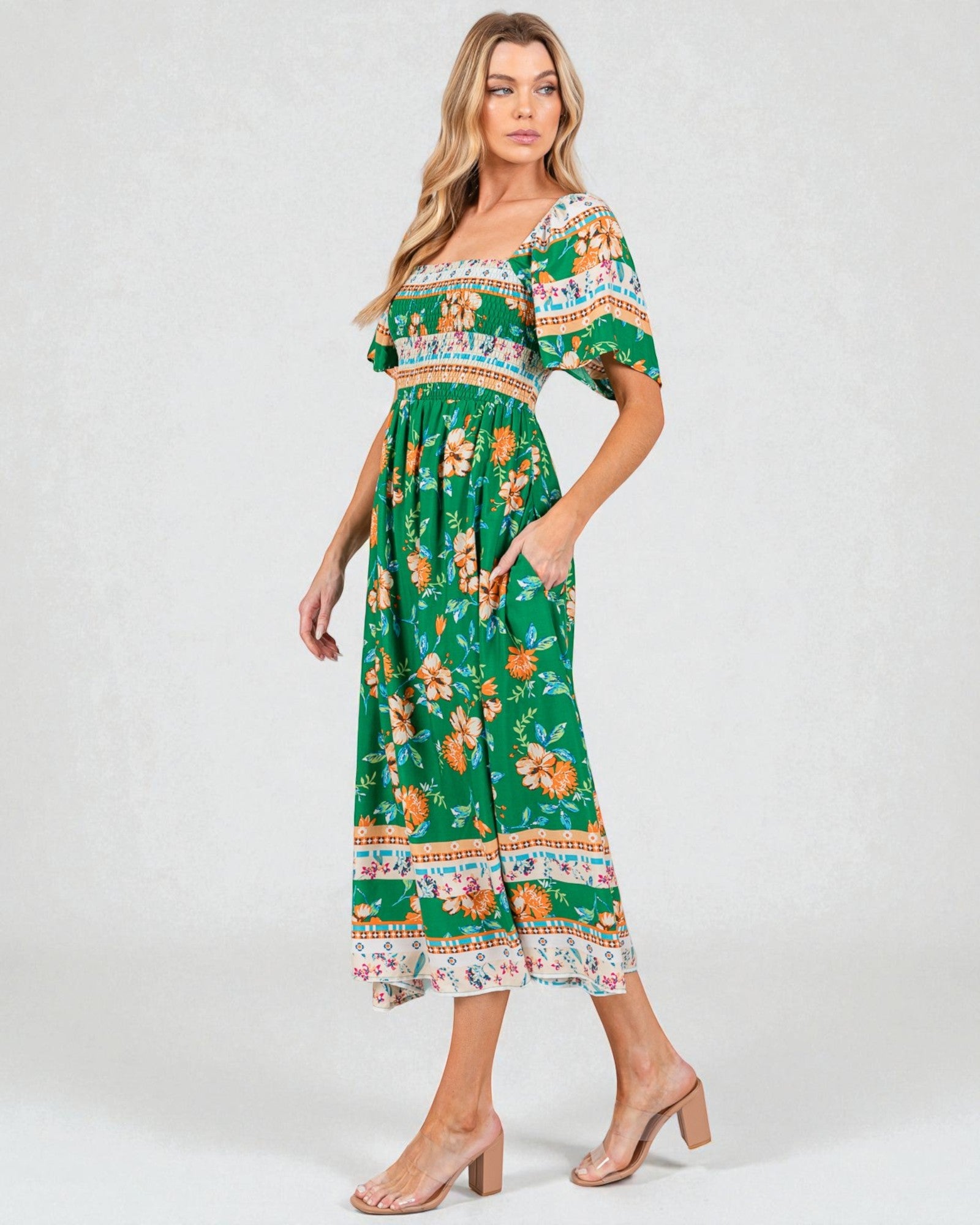 Woman wearing a green floral dress on a white background