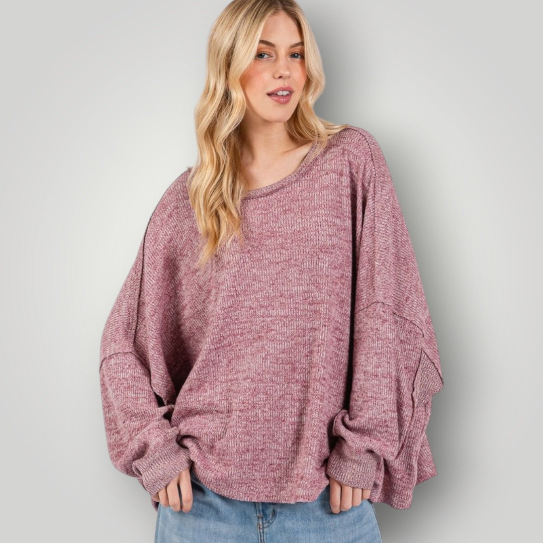 Woman wearing a pink sweater against a plain background