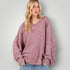 Woman wearing a pink sweater against a plain background