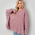 Woman wearing a pink marled sweater against a plain background