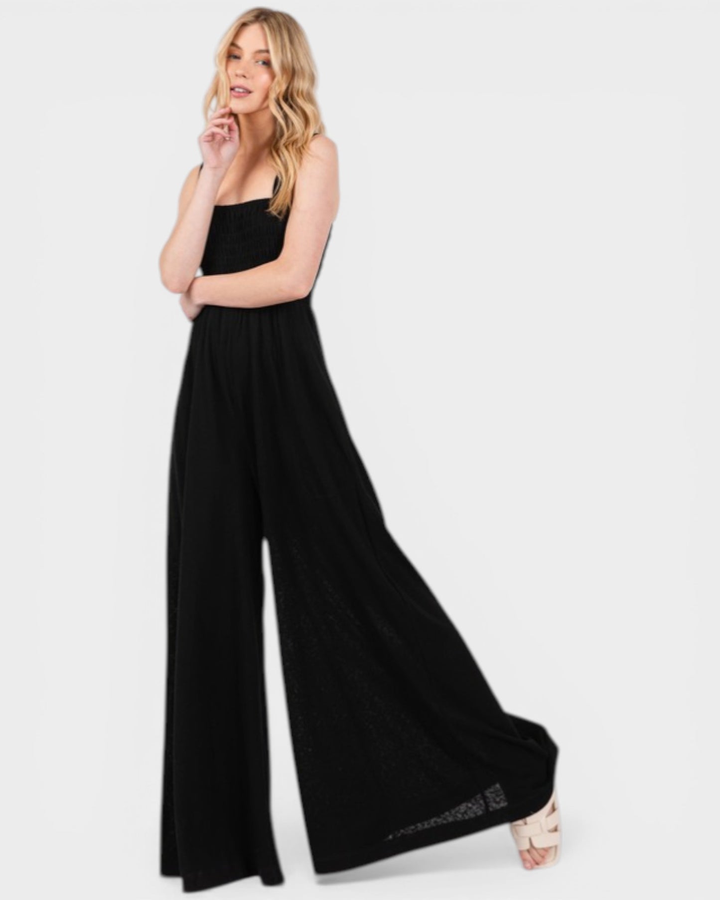 Woman wearing a black jumpsuit on a white background