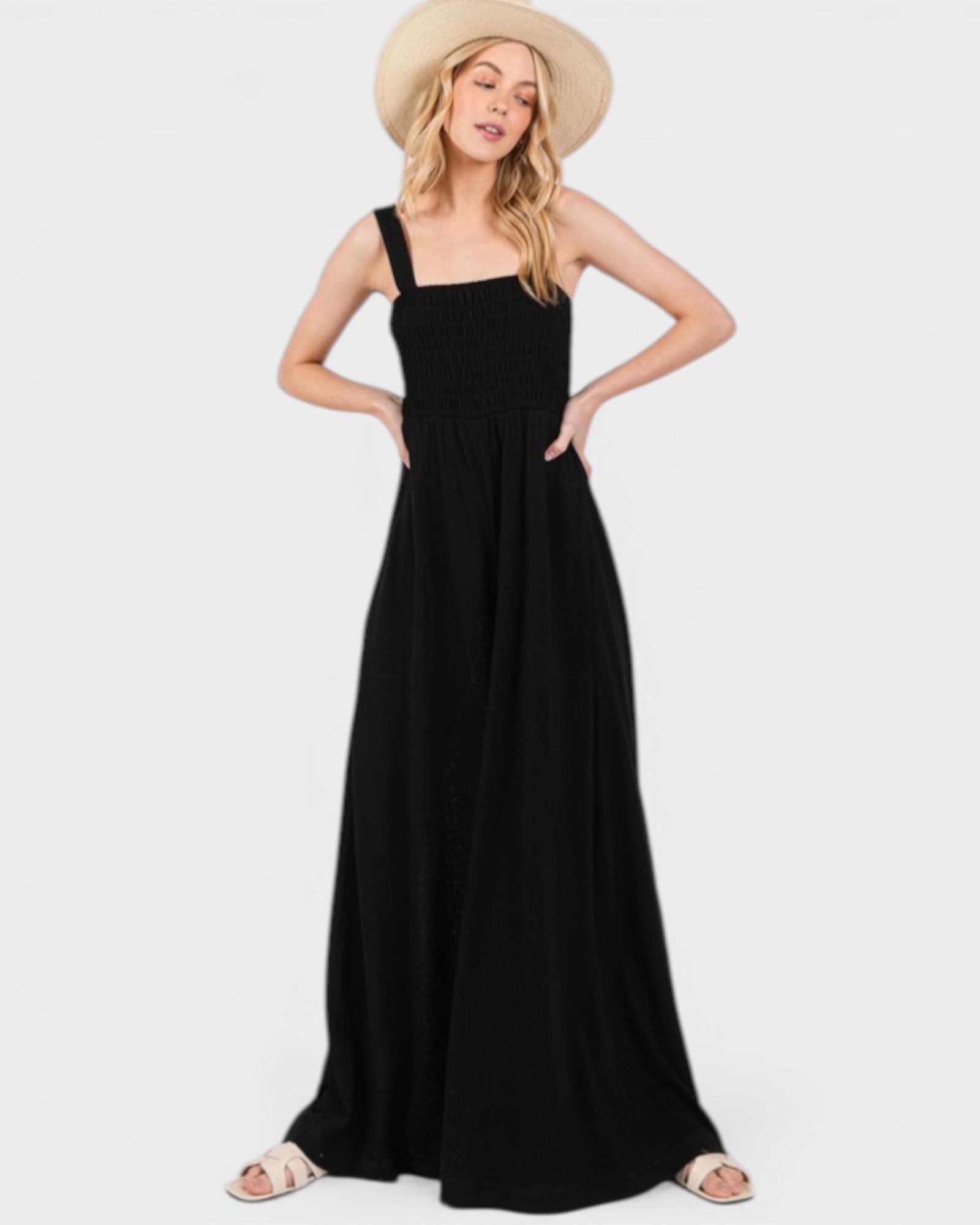 Woman wearing a black dress and straw hat on a white background