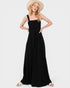 Woman wearing a black dress and straw hat on a white background