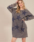 Woman wearing a gray sweatshirt dress with star patterns on a beige background