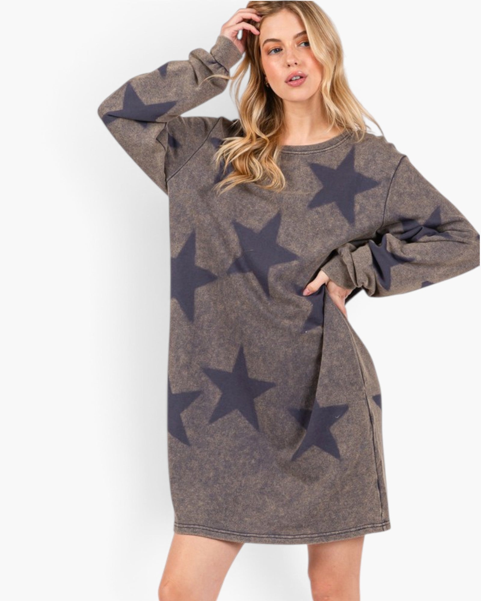A woman modeling a long-sleeve crewneck sweatshirt dress in a washed charcoal gray color with a dark navy star pattern, set against a plain white background.
