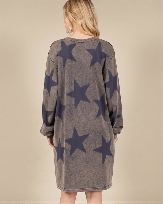 Woman wearing a brown dress with star patterns on the back against a beige background