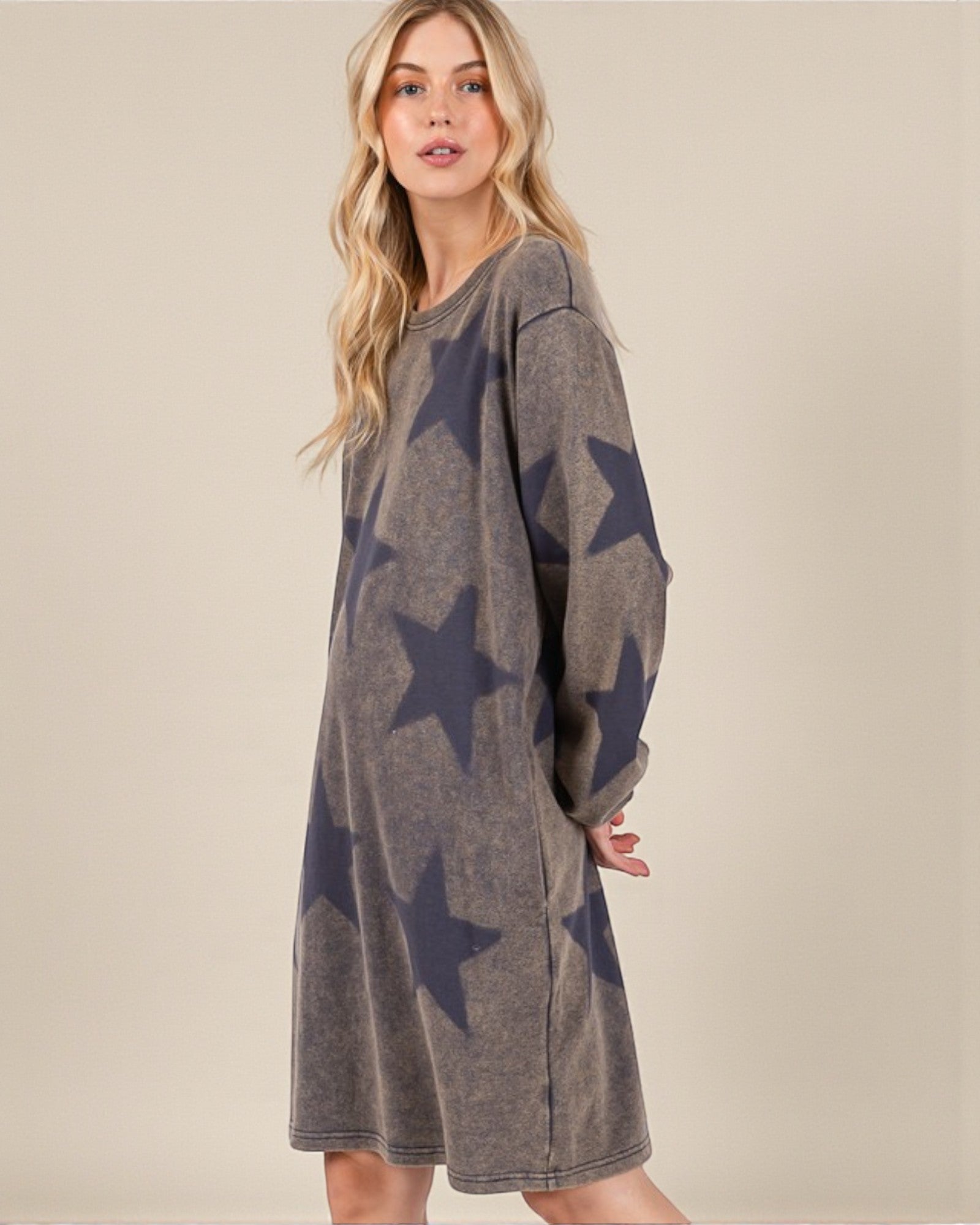 Woman wearing a gray dress with star patterns on a beige background