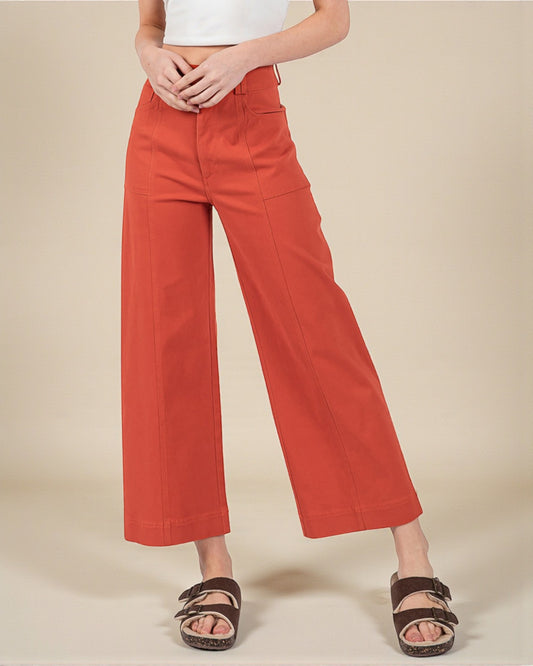 Person wearing red pants on a beige background