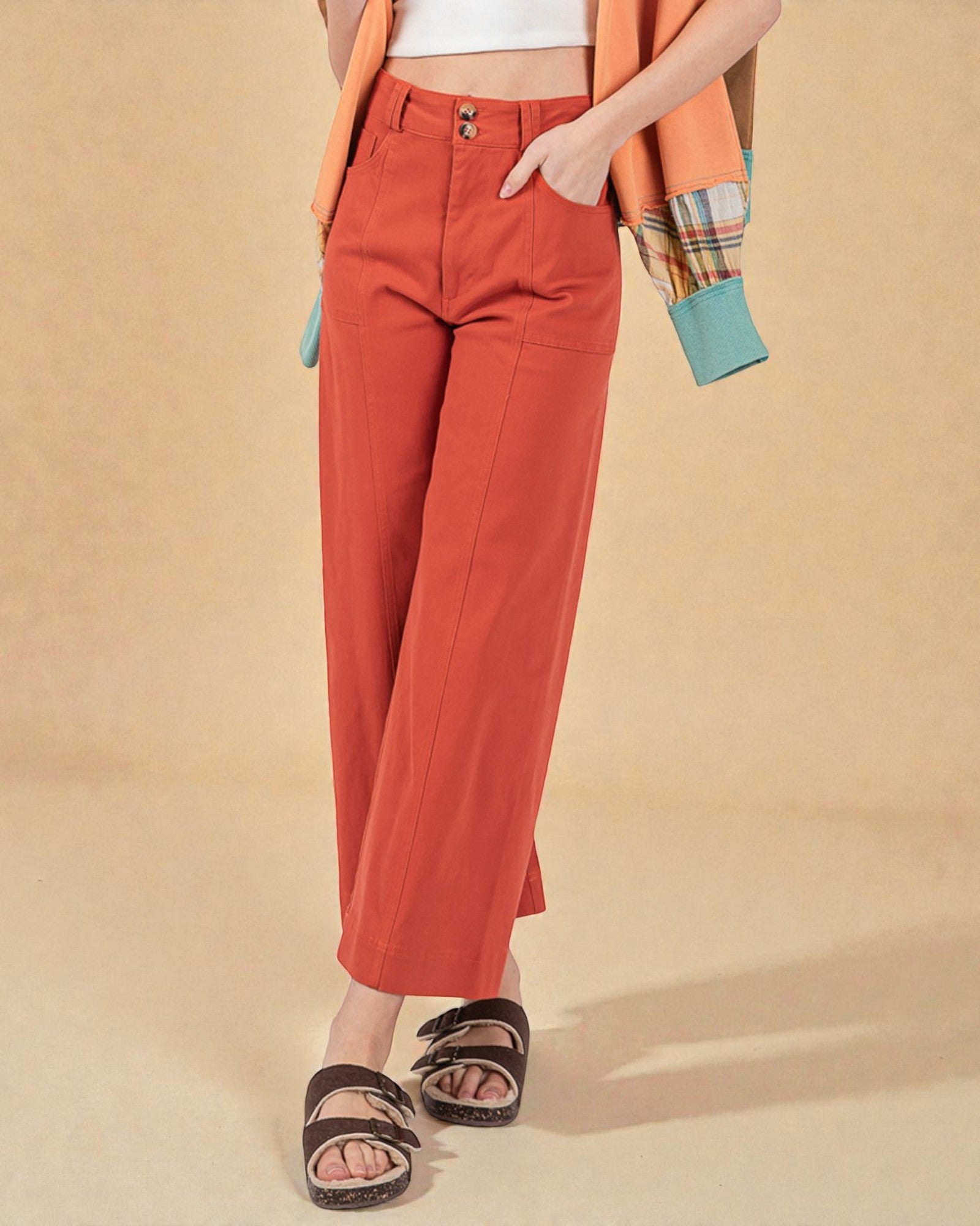 Person wearing orange pants on a beige background