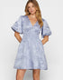 Woman wearing a blue patterned dress on a white background