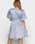 Woman wearing a blue patterned dress on a white background