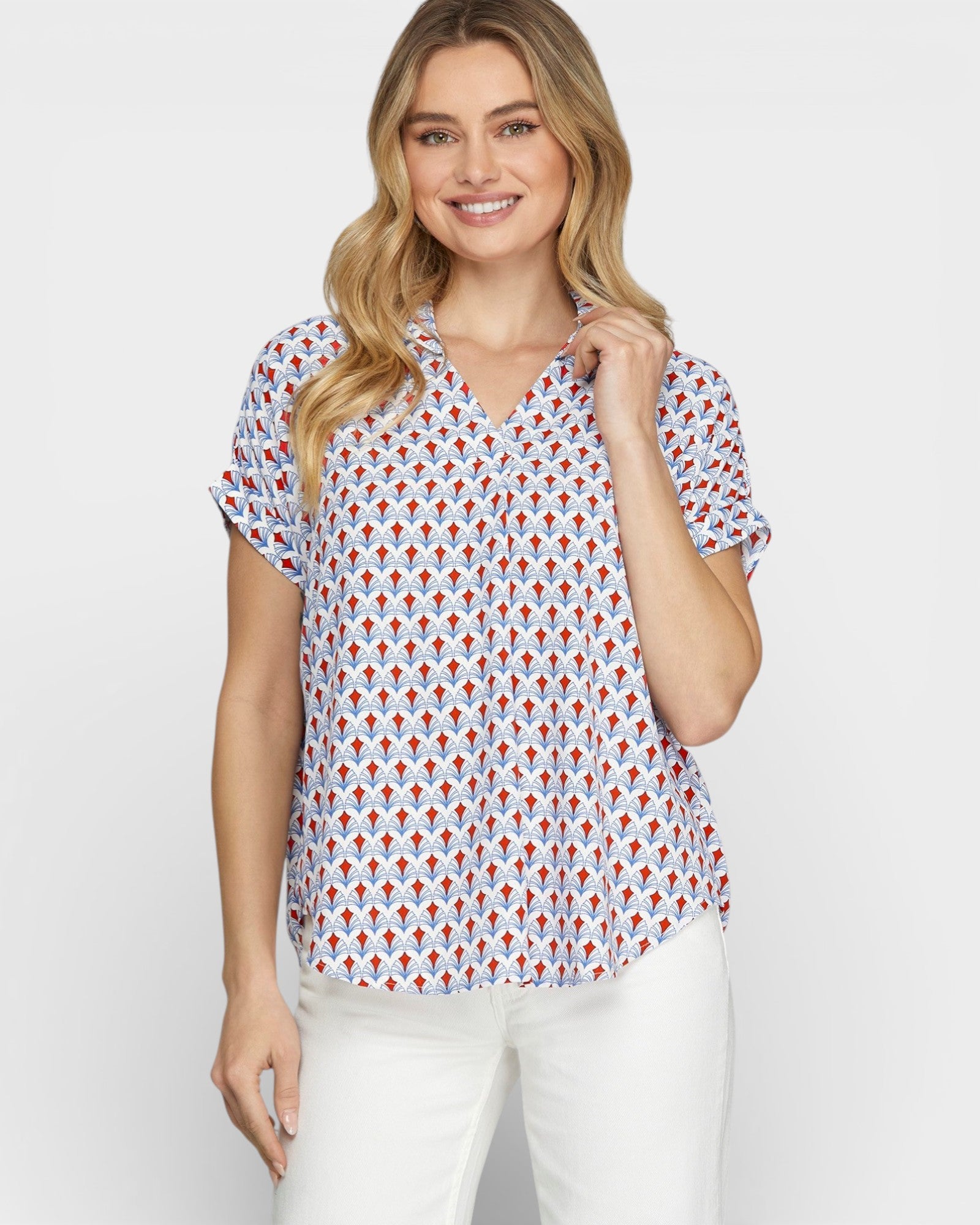 Woman wearing a patterned blouse with a plain background