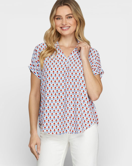 Woman wearing a patterned blouse with a plain background