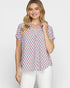 Woman wearing a patterned blouse with a plain background