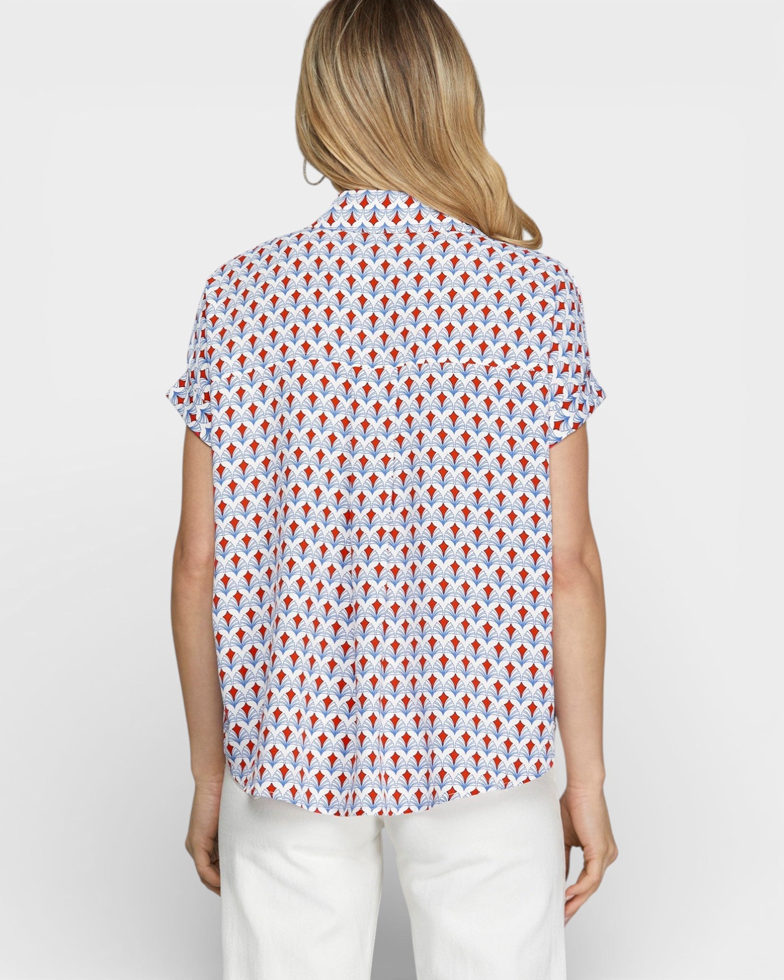 Woman wearing a patterned shirt with a plain background