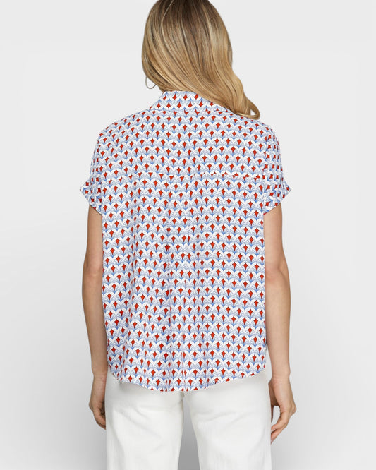 Woman wearing a patterned shirt with a plain background