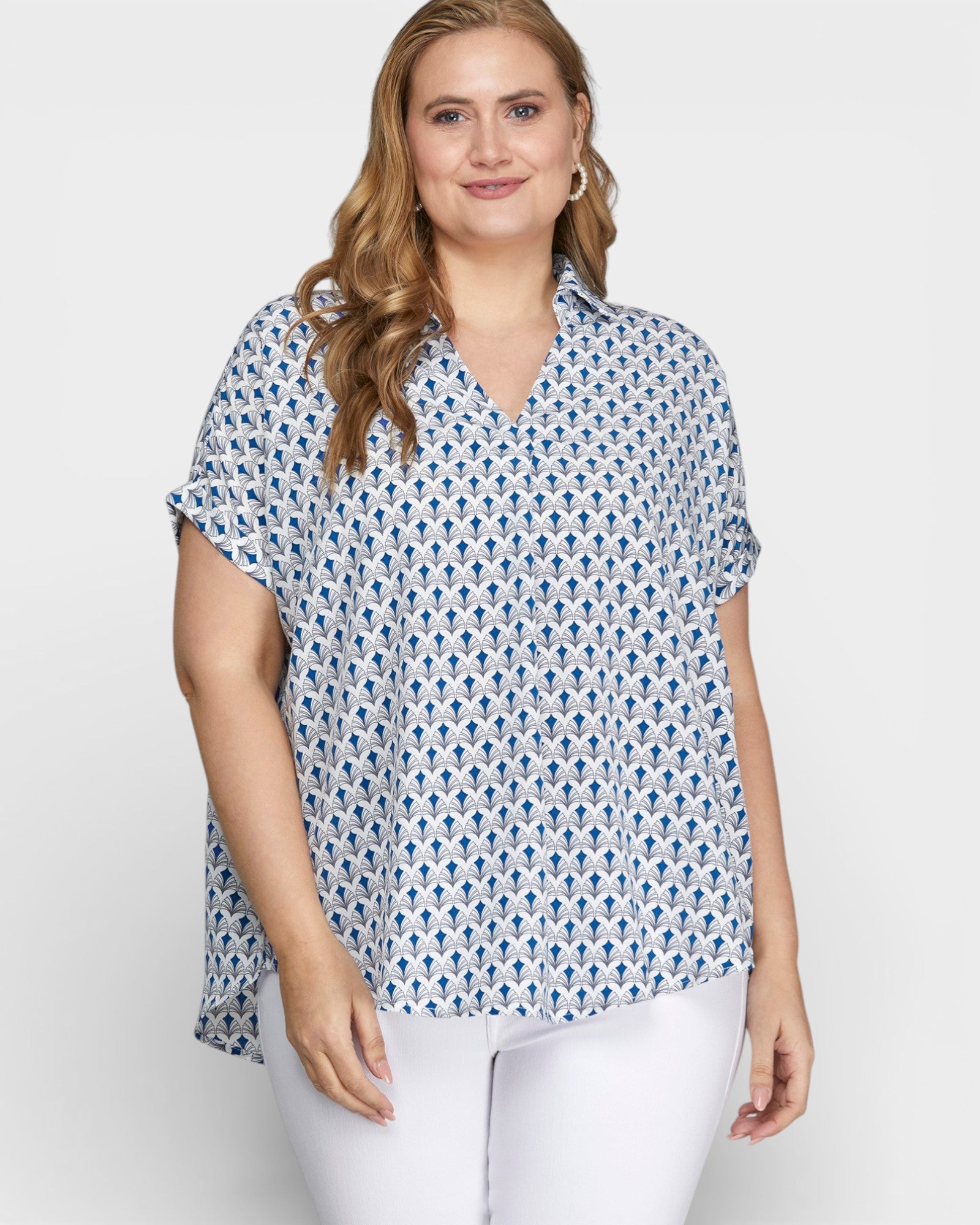 Woman wearing a patterned blue and white shirt against a plain background