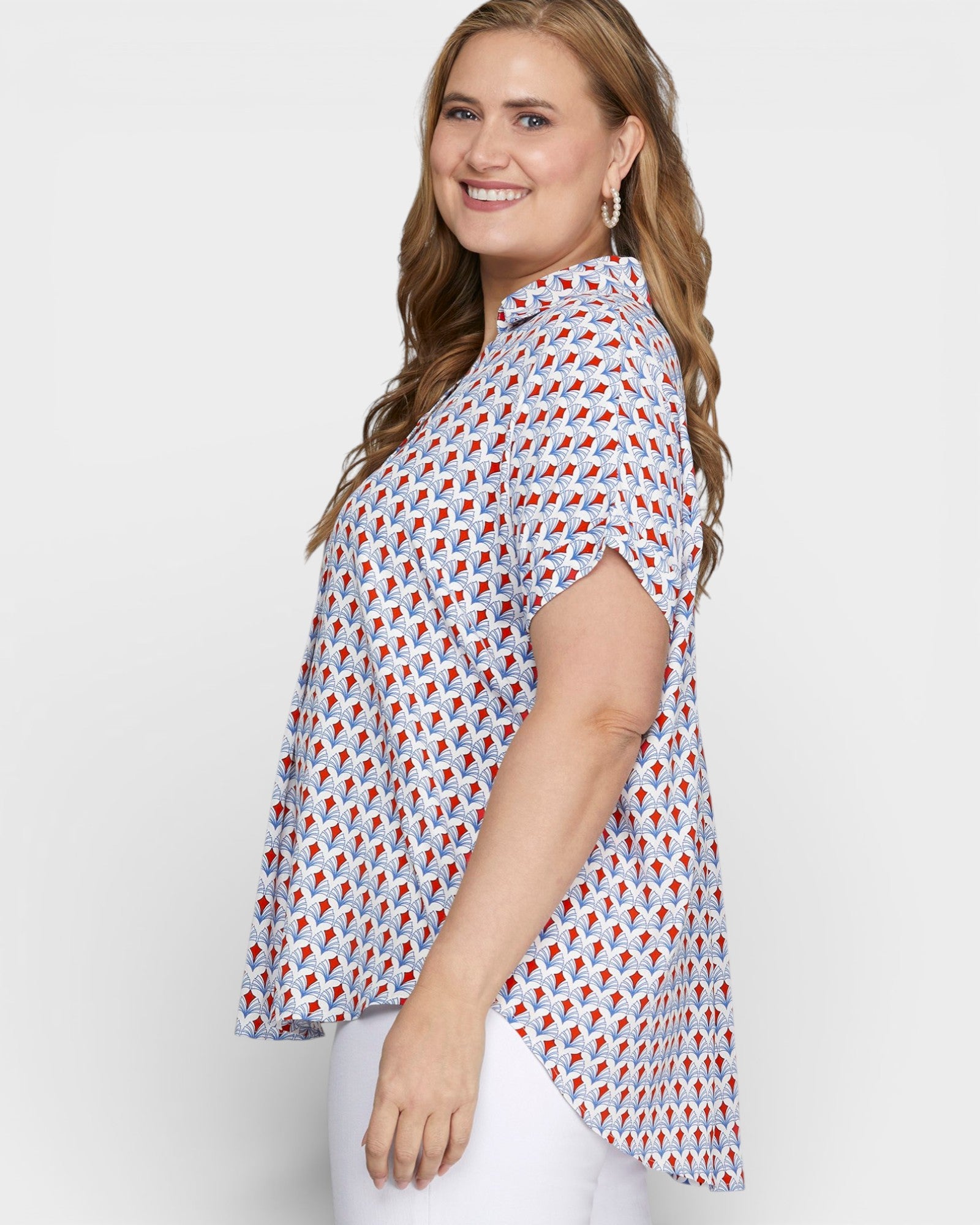 Woman wearing a patterned blouse with a plain background