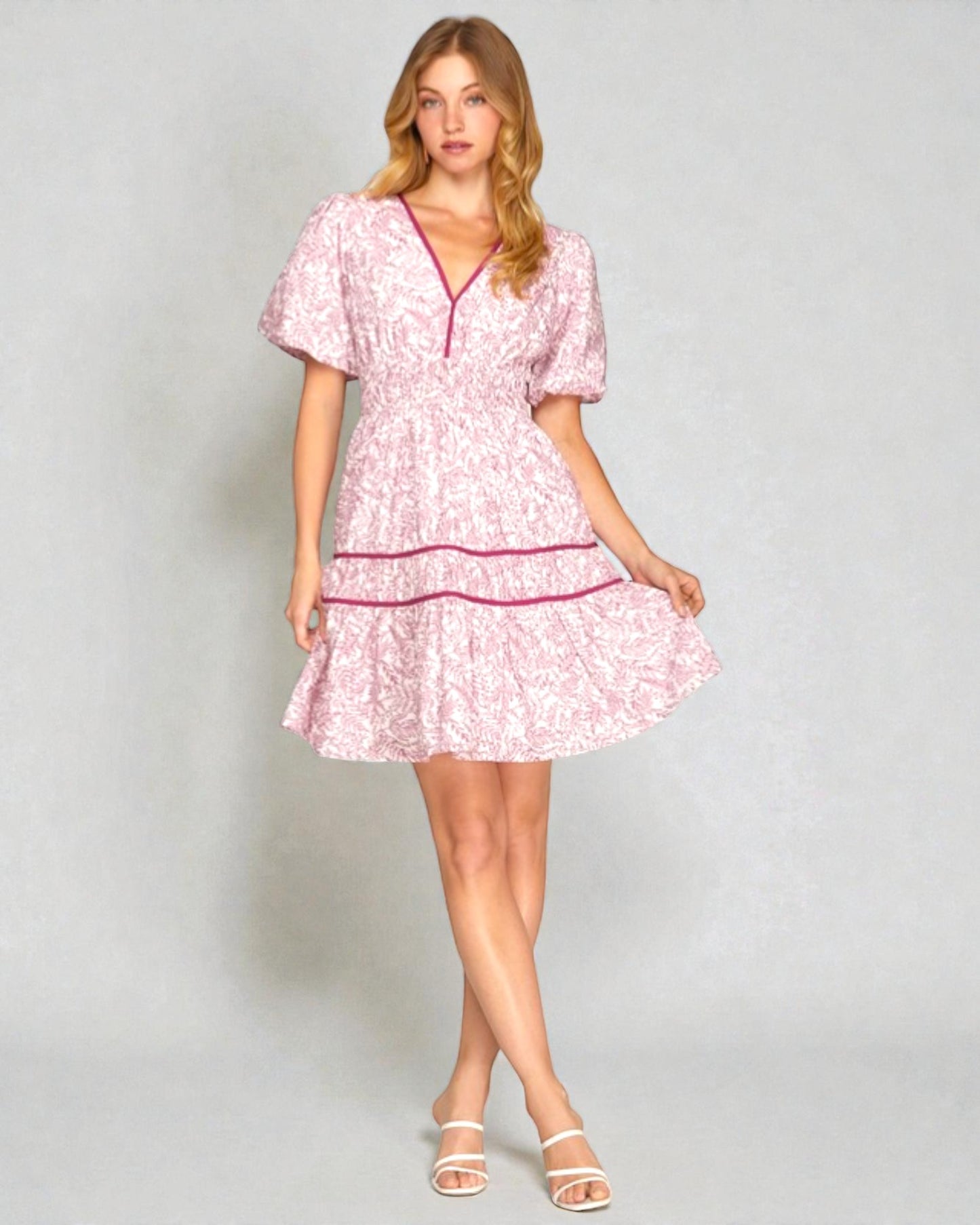 Woman wearing a pink floral dress on a gray background