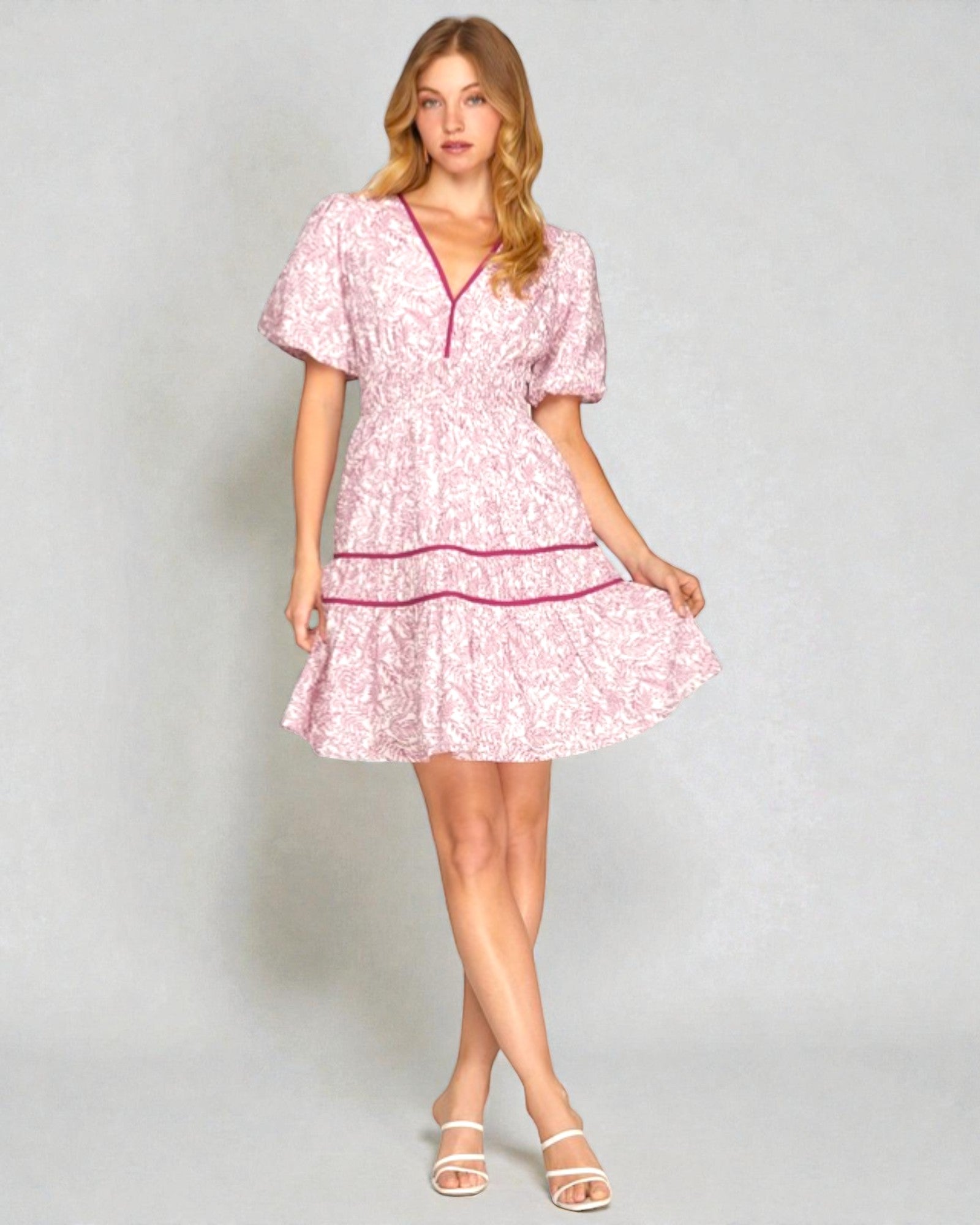 Woman wearing a pink floral dress on a gray background