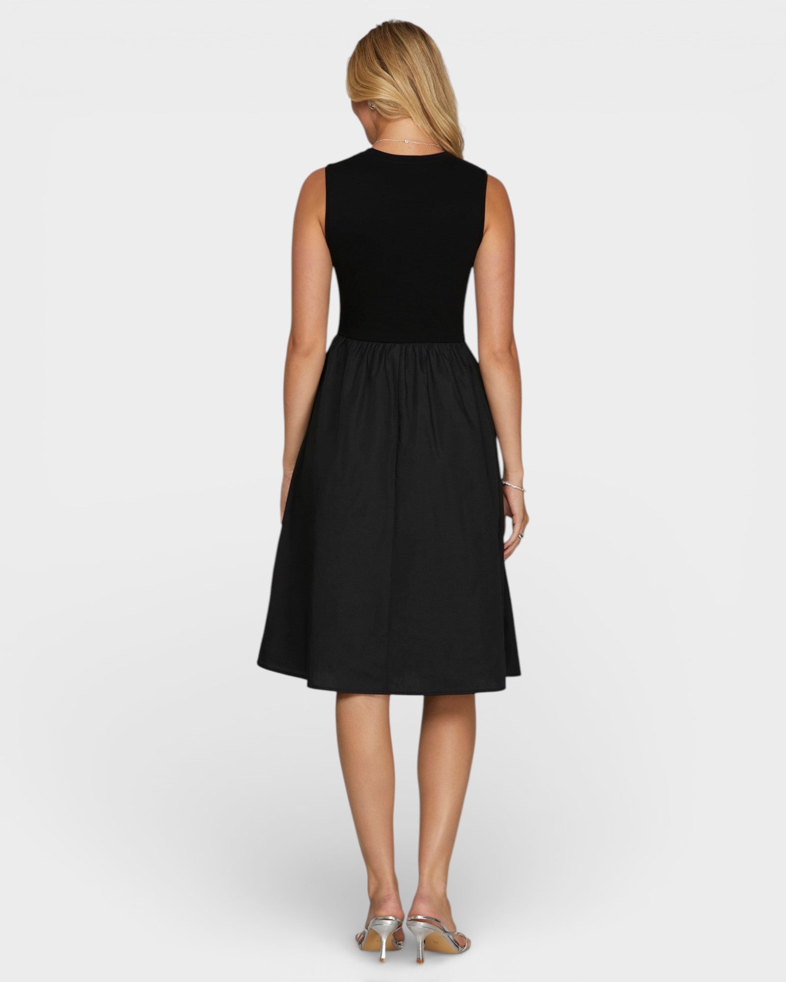 Woman wearing a black sleeveless dress on a white background