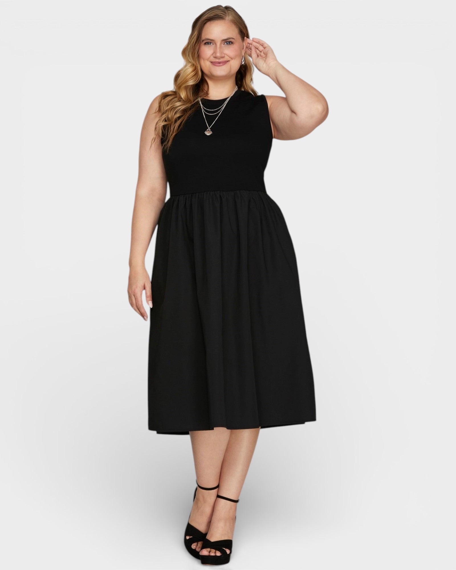 Woman wearing a black sleeveless dress on a white background