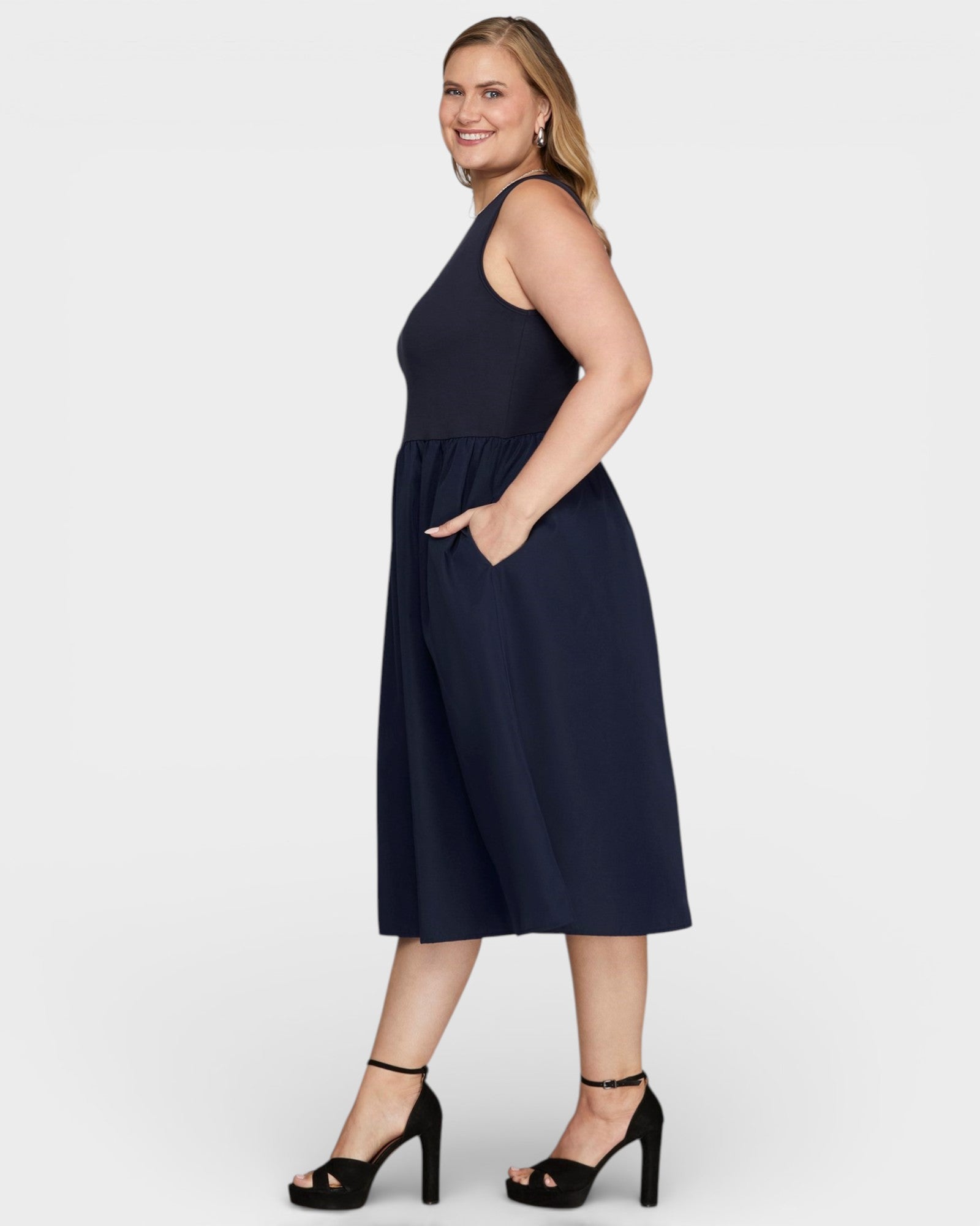 Woman wearing a navy dress on a white background