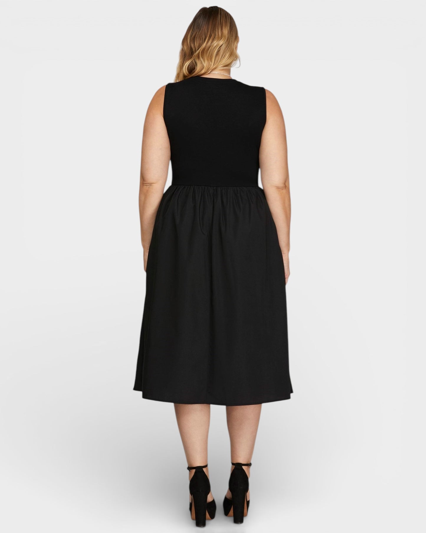 Woman wearing a black sleeveless dress on a white background