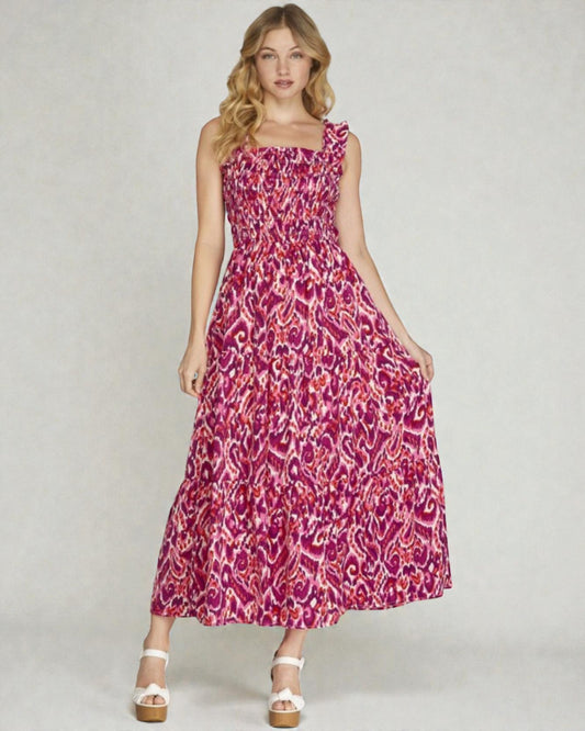 Woman wearing a pink patterned dress on a plain background