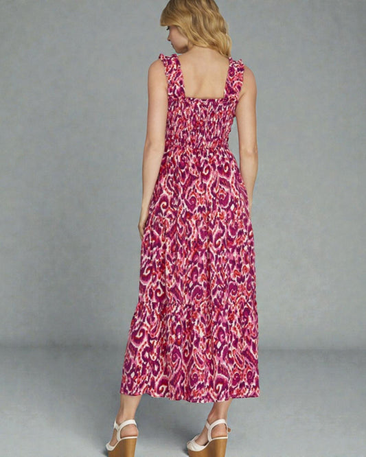 Woman wearing a pink patterned dress against a gray background