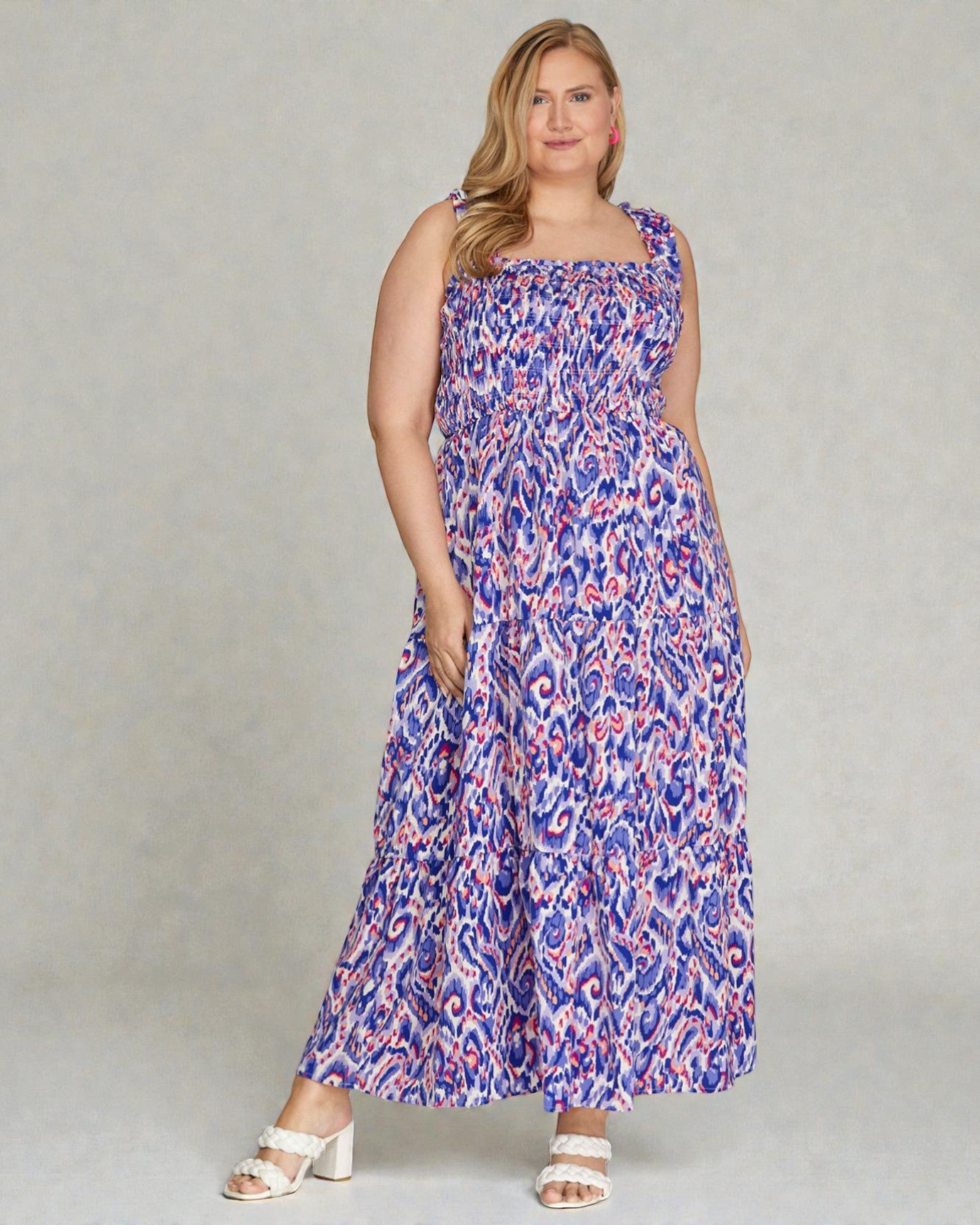 Woman wearing a blue and pink patterned dress against a gray background