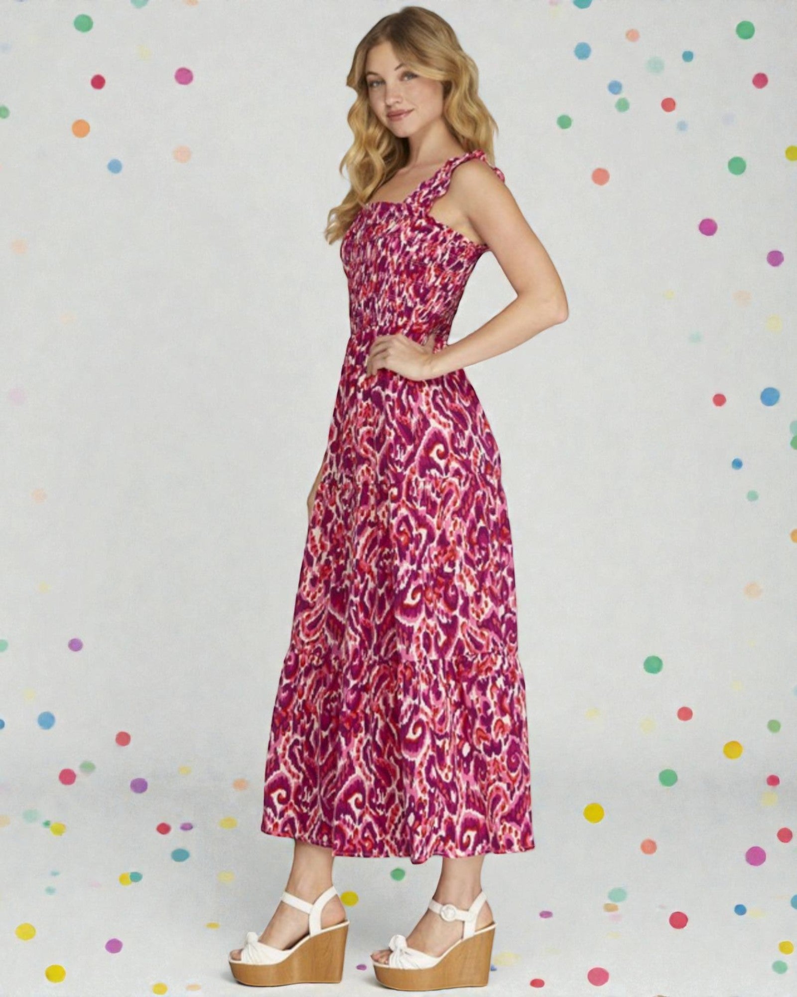 Woman wearing a pink patterned dress against a polka dot background