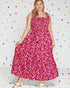 Woman wearing a pink patterned dress against a polka dot background