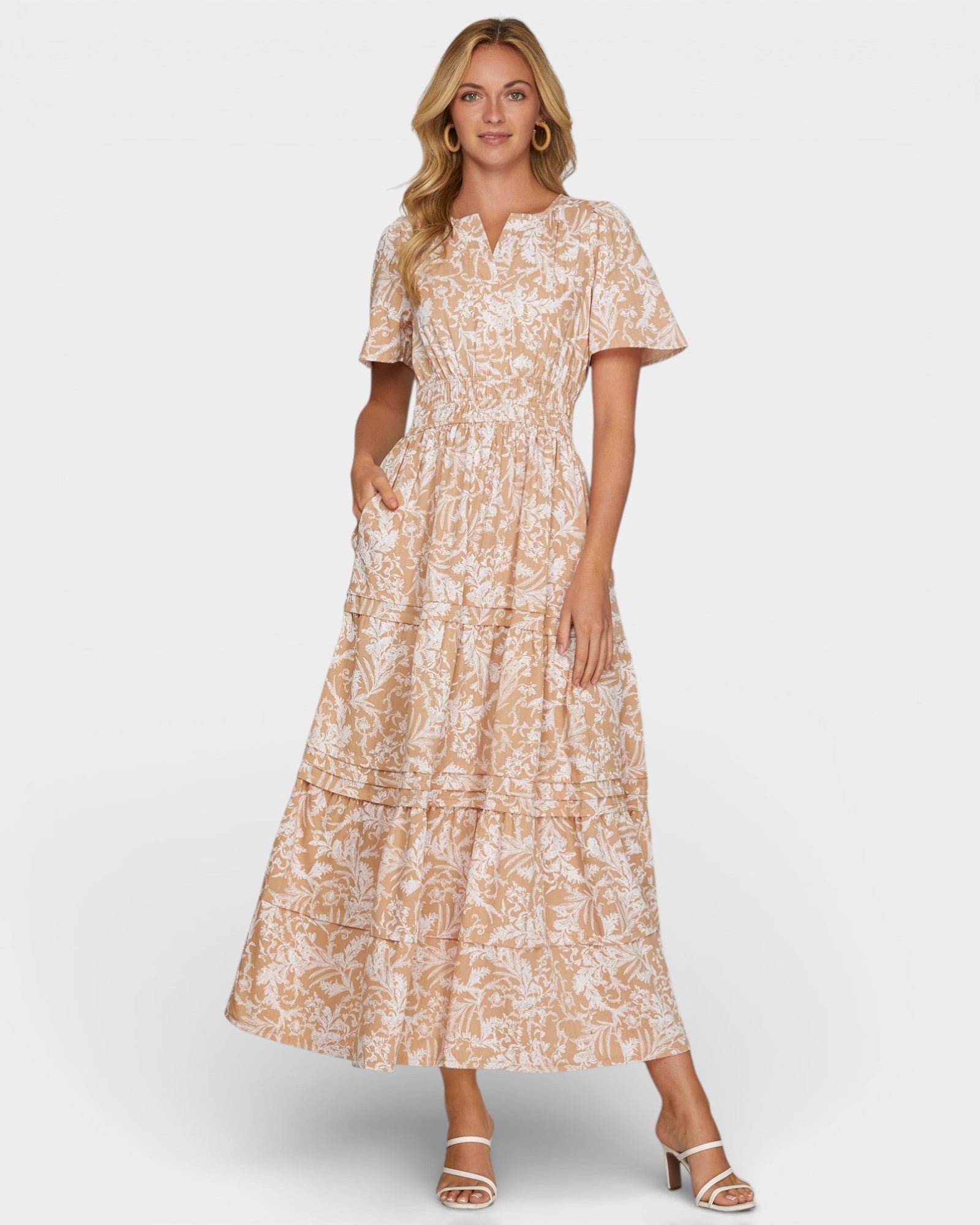 Woman wearing a beige floral dress on a white background