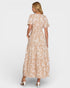 Woman wearing a beige floral dress on a white background