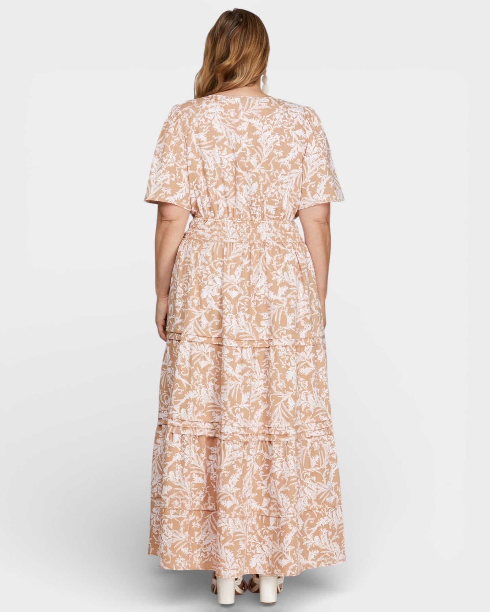 Woman wearing a floral dress on a plain background