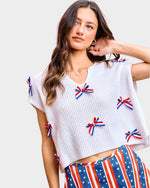 woman wearing white blouse with red white and blue bows