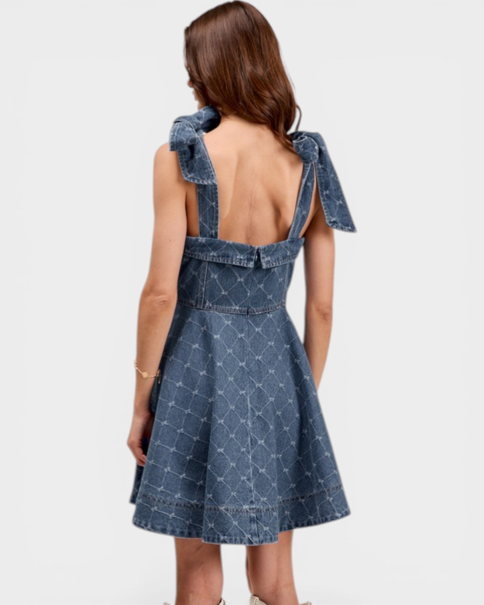 Blue denim dress with bow straps on a white background