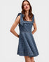 Woman wearing a denim dress with bow straps on a white background