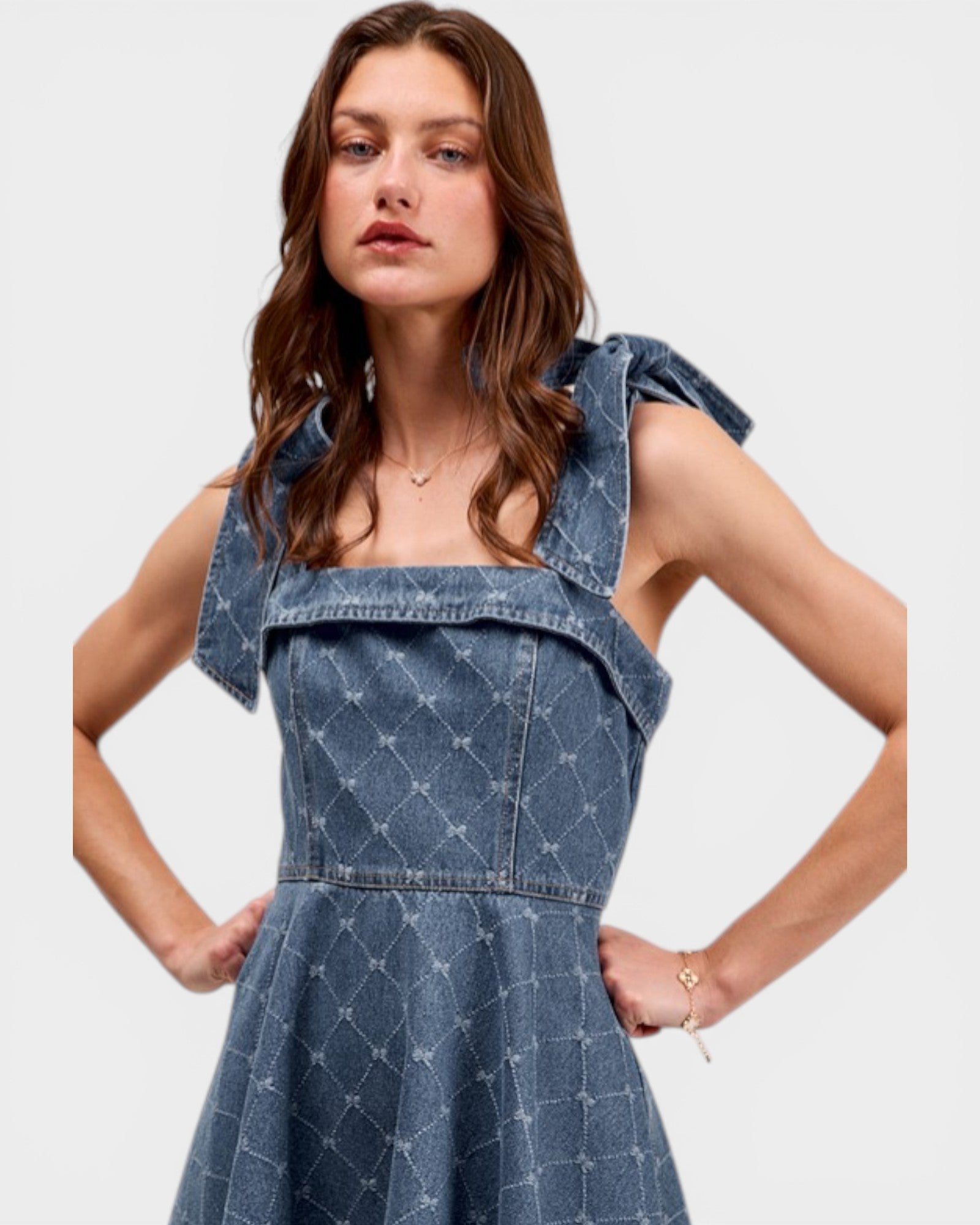 Woman wearing a blue denim dress with a white background