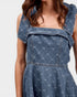 Blue denim dress with ruffled shoulders on a white background