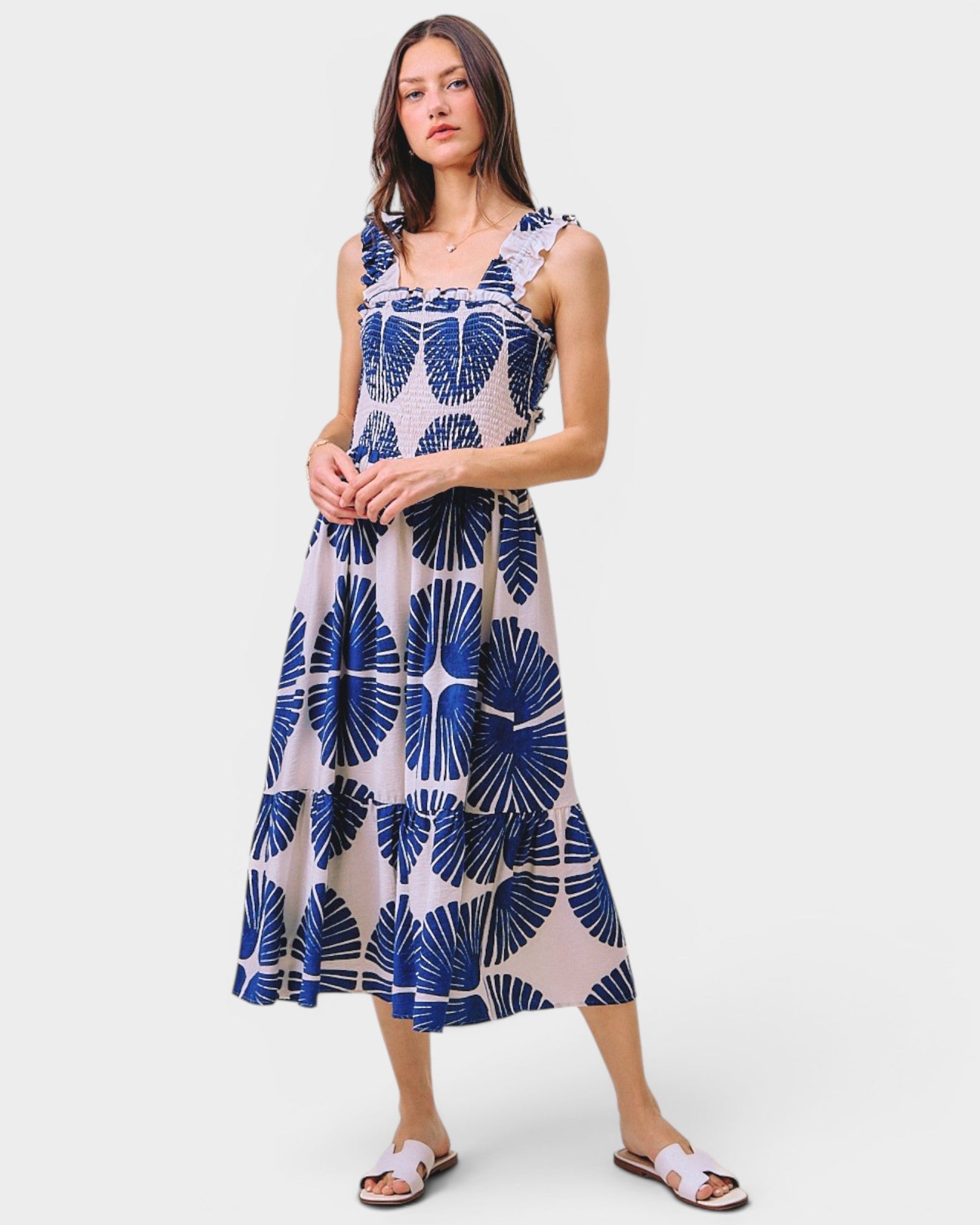 Woman wearing a blue and white patterned dress on a white background