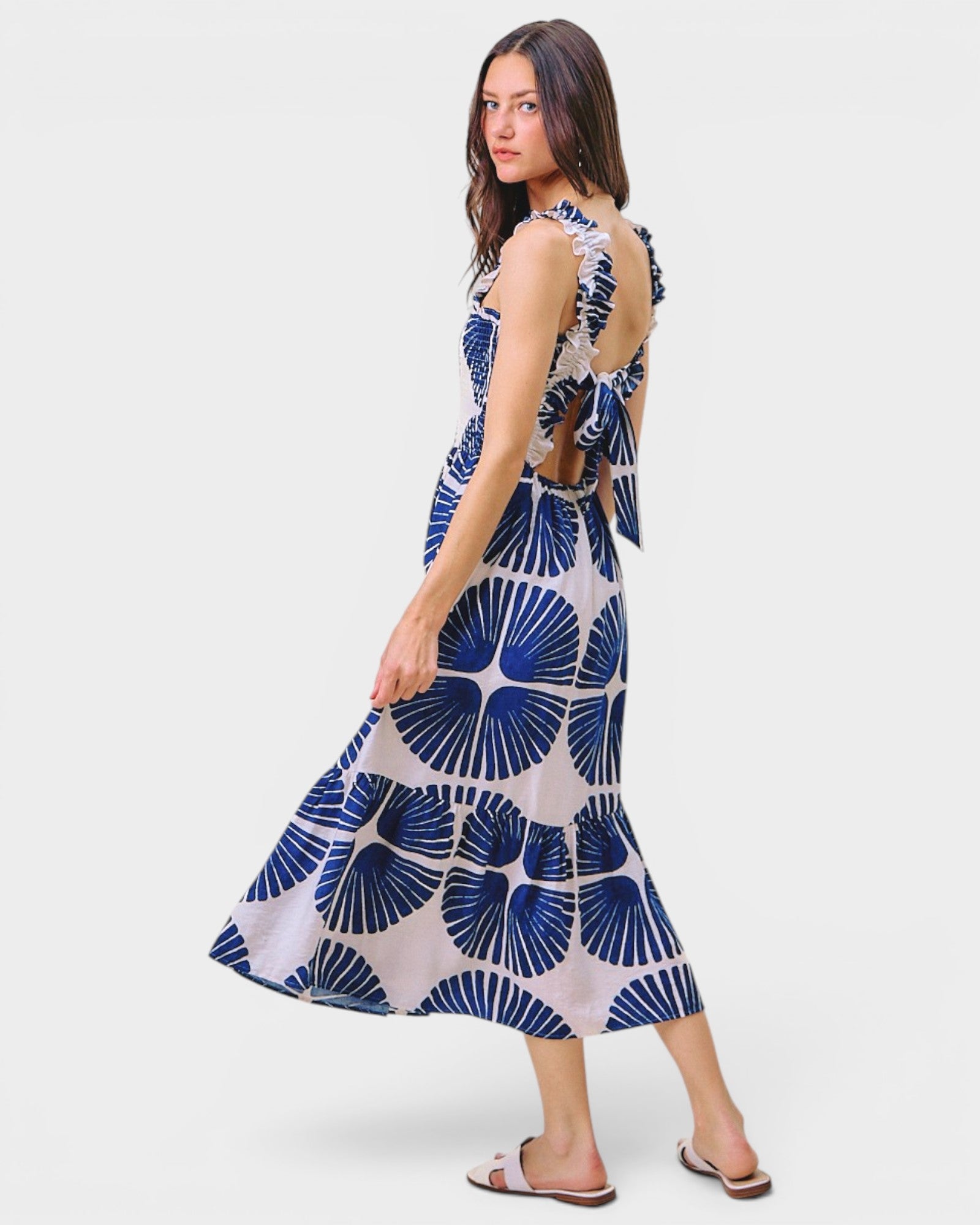Woman wearing a blue and white patterned dress on a white background