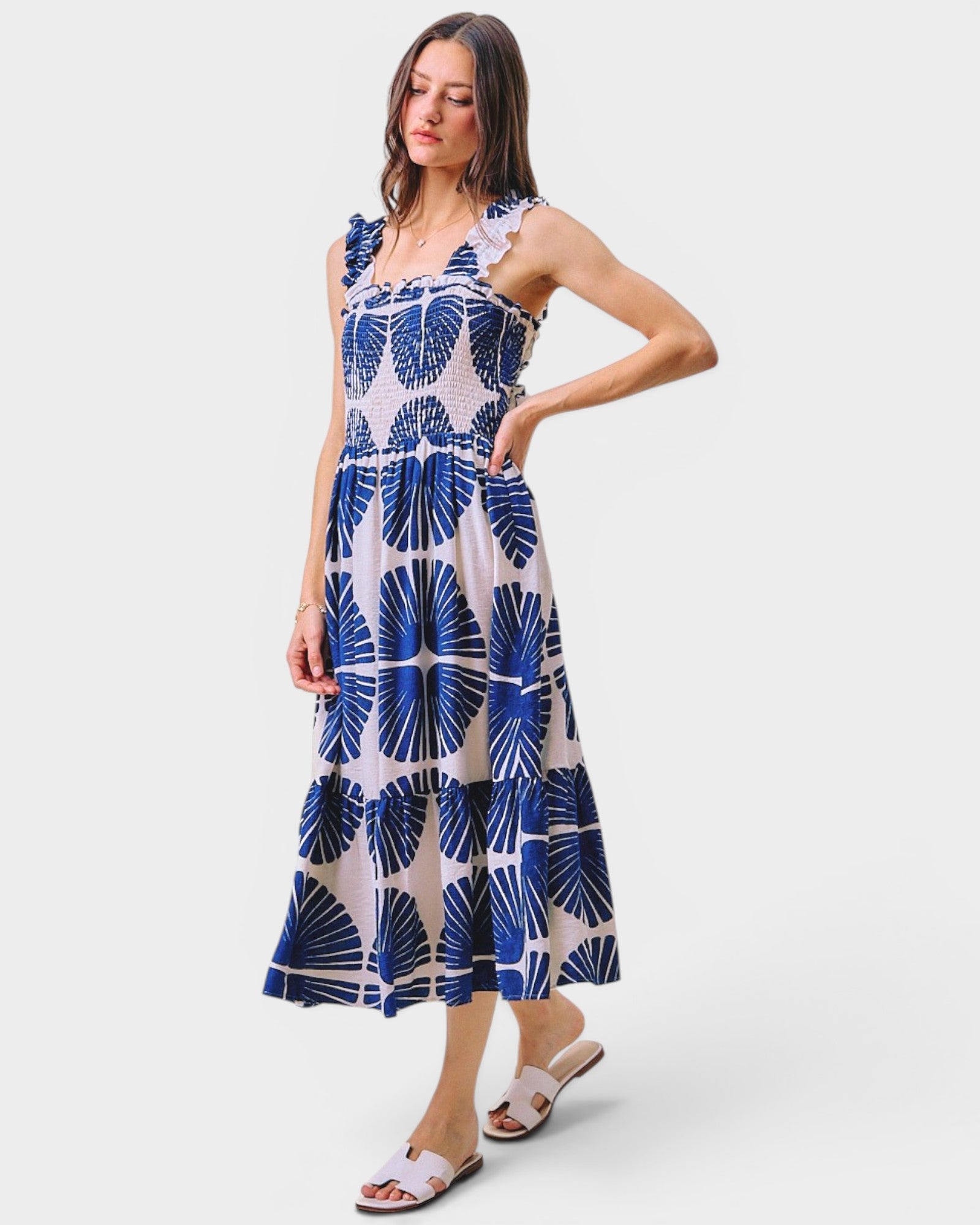 Woman wearing a blue and white patterned dress on a white background